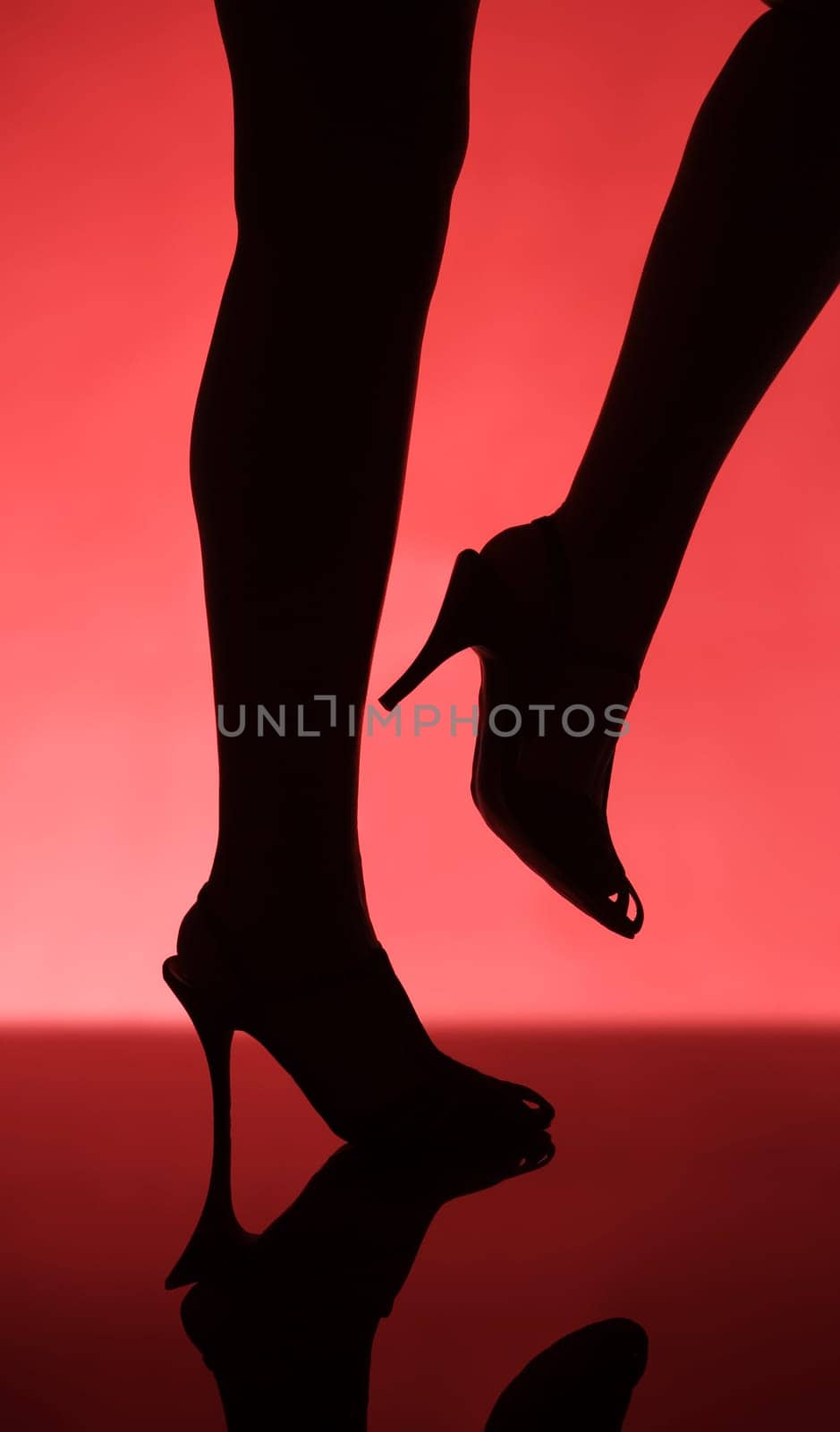 Woman on the catwalk towards red background