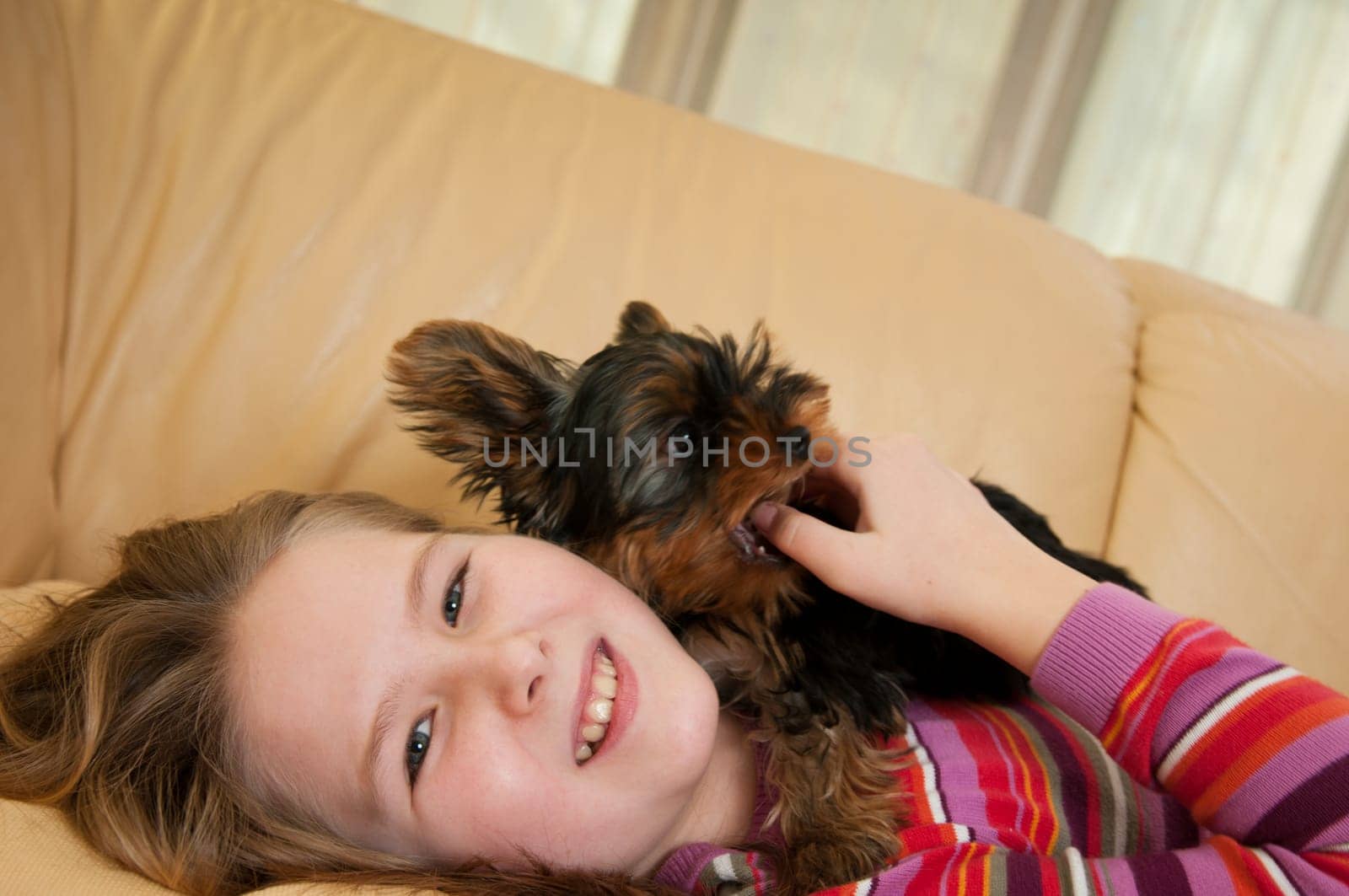 Portrait of cute child (girl) relaxing with little dog