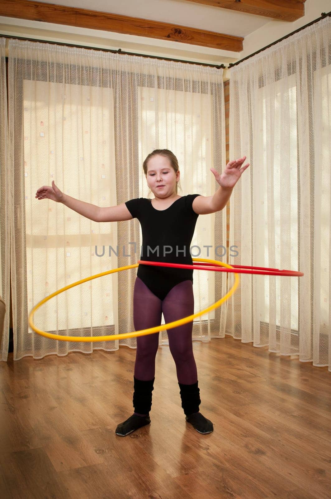 Young girl show gymnastics dance with hoop at home
