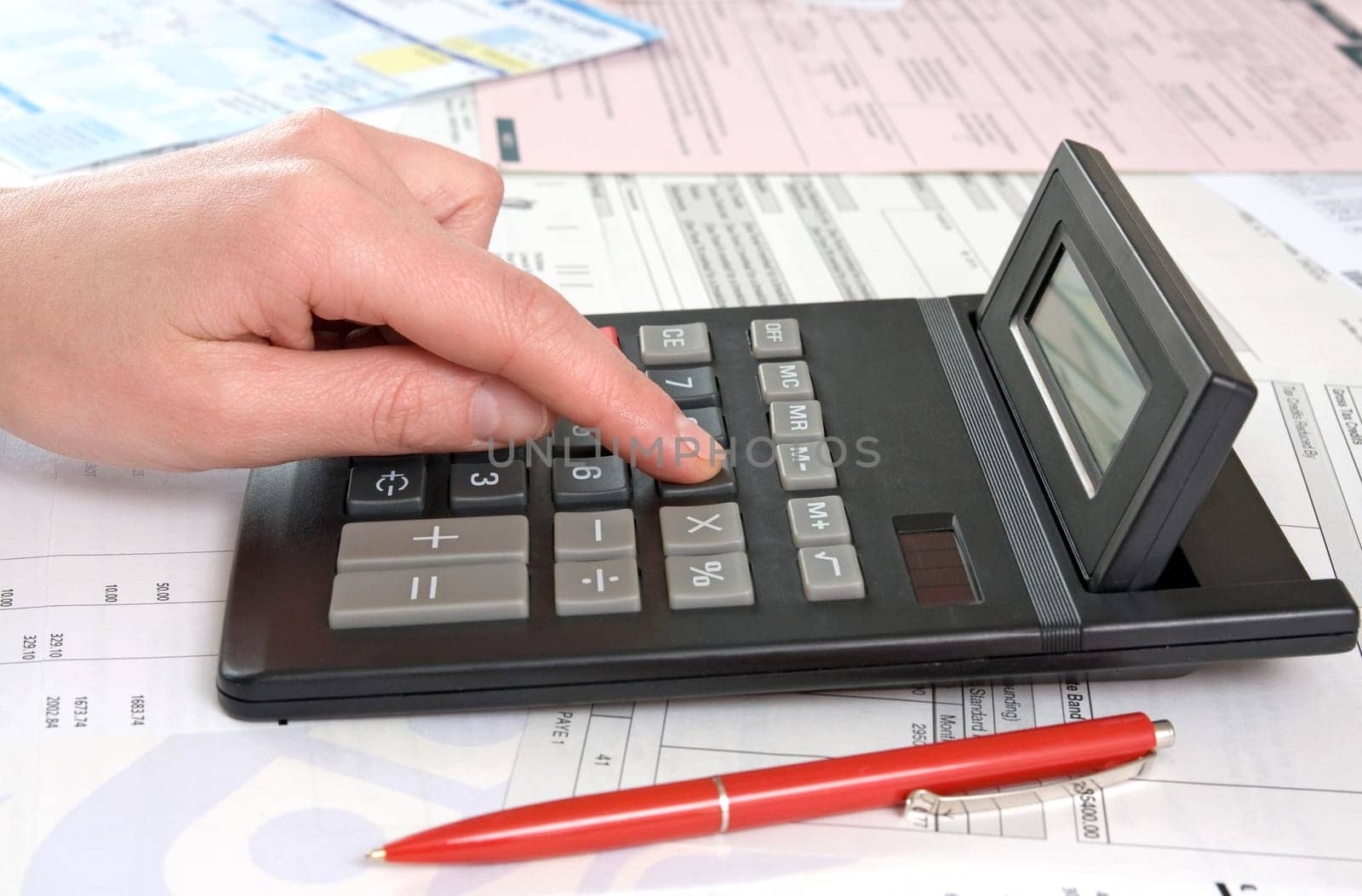 female hand,calculator and financial reports