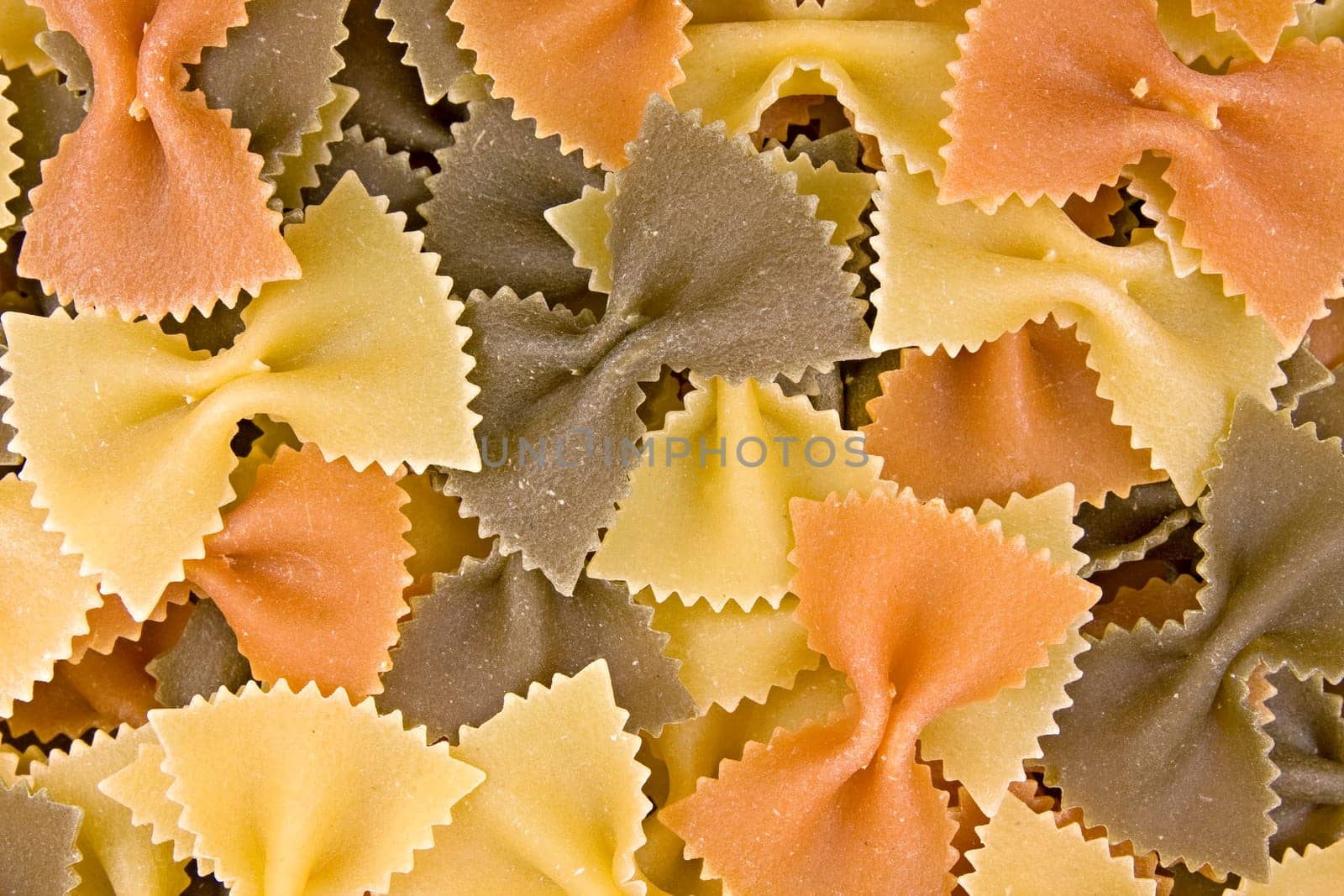 close up of uncooked multi-colored bow pasta