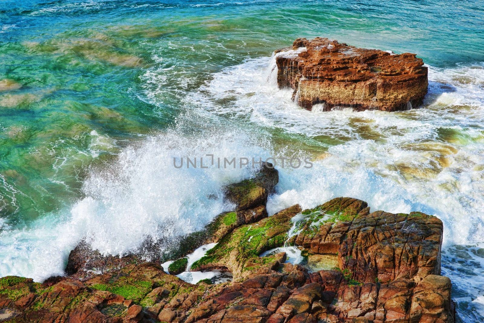 ocean waves crash on to rocks at the coast