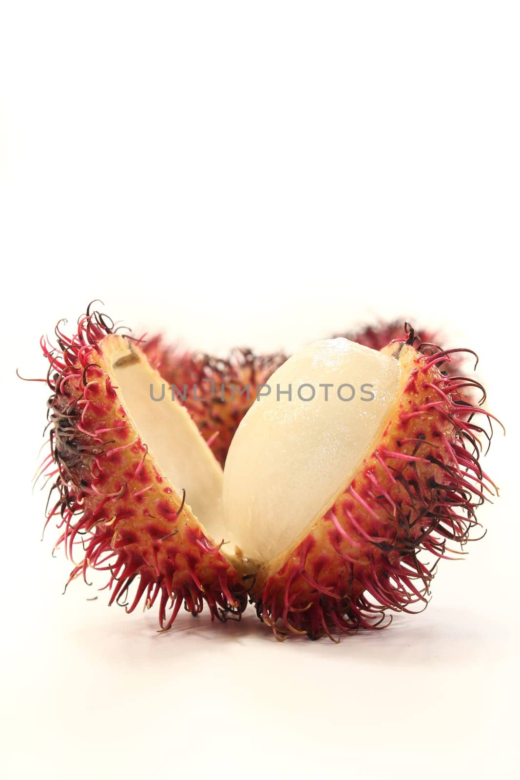 four rambutan fruits against white background