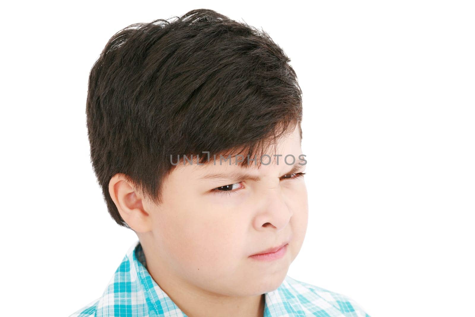Close-up portrait of angry little boy isolated on white background