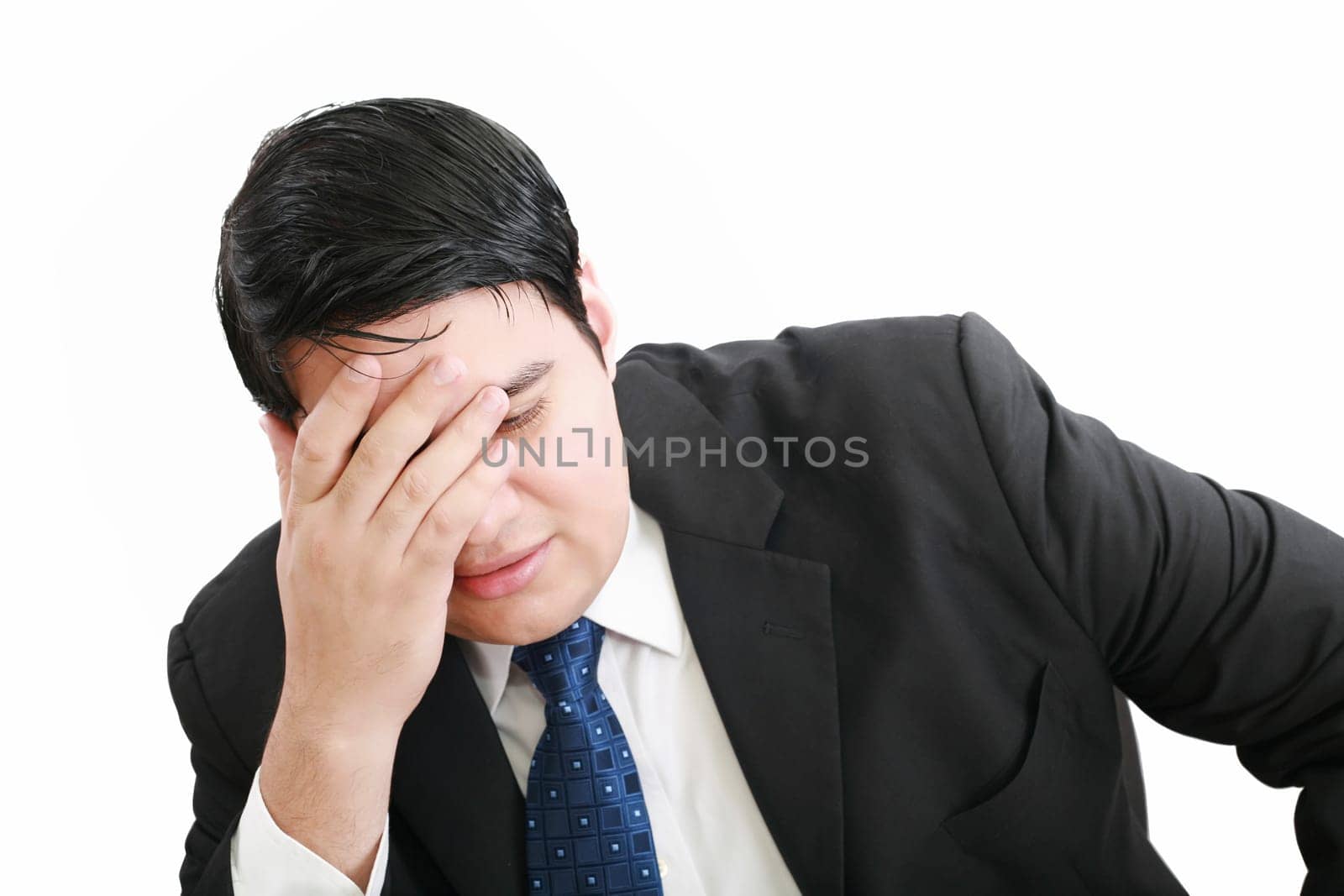 Portrait of a young business man depressed from work against white background