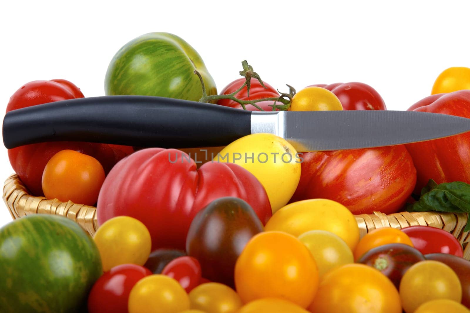 Numerous biotomets in basket with knife against white background