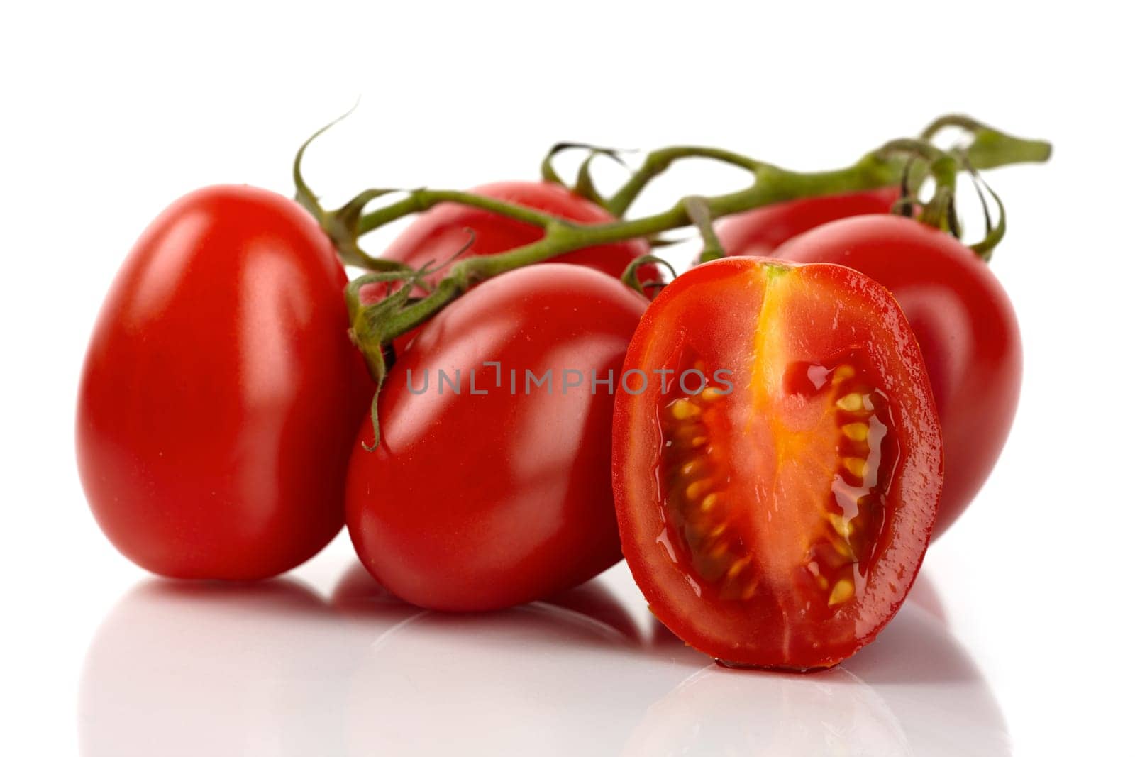 Fresh Roma tomatoes cut against white background