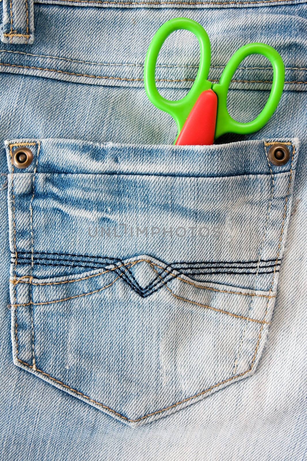 concept for  fashion and style. scissors in a jeans pocket.