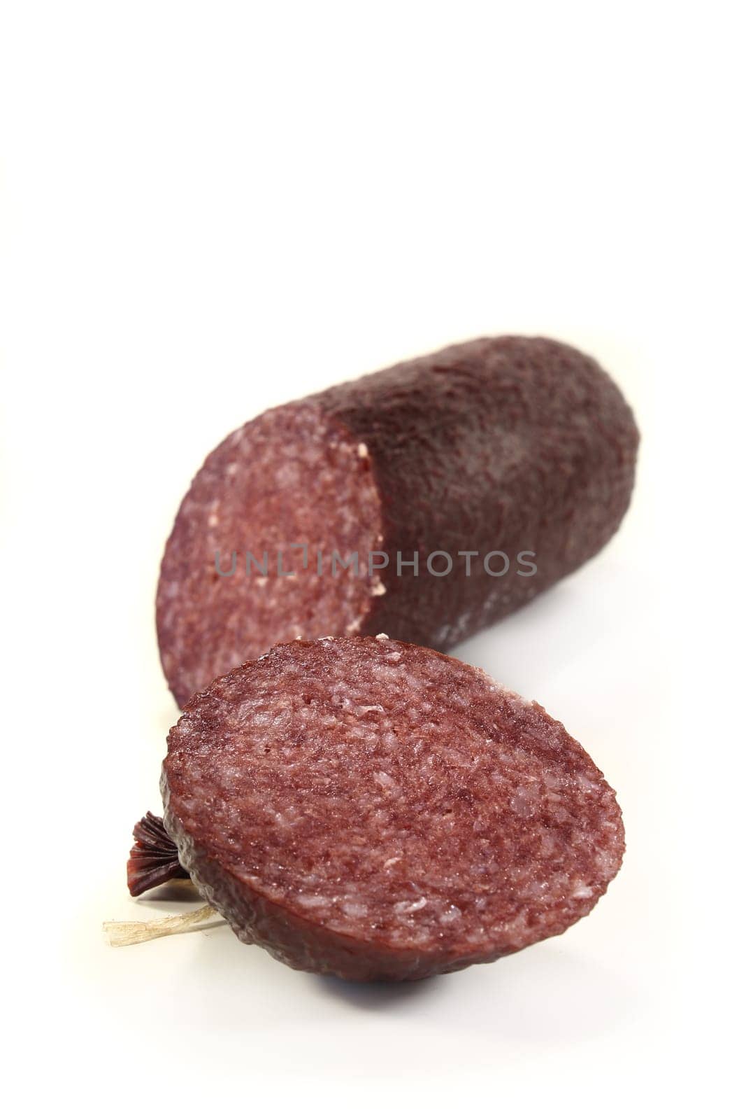 a sliced salami against a white background