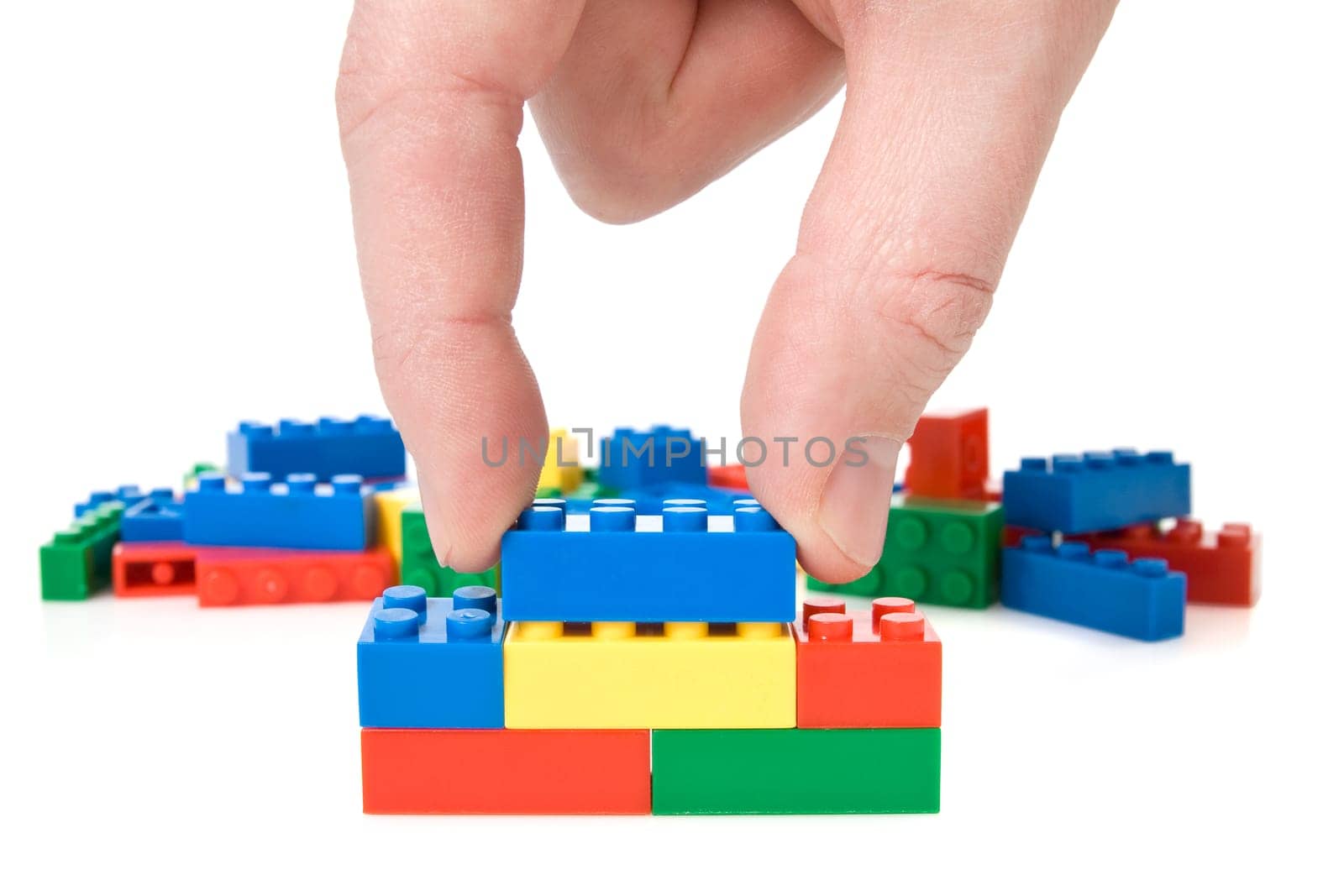 close-up of hand building a color plastic bricks