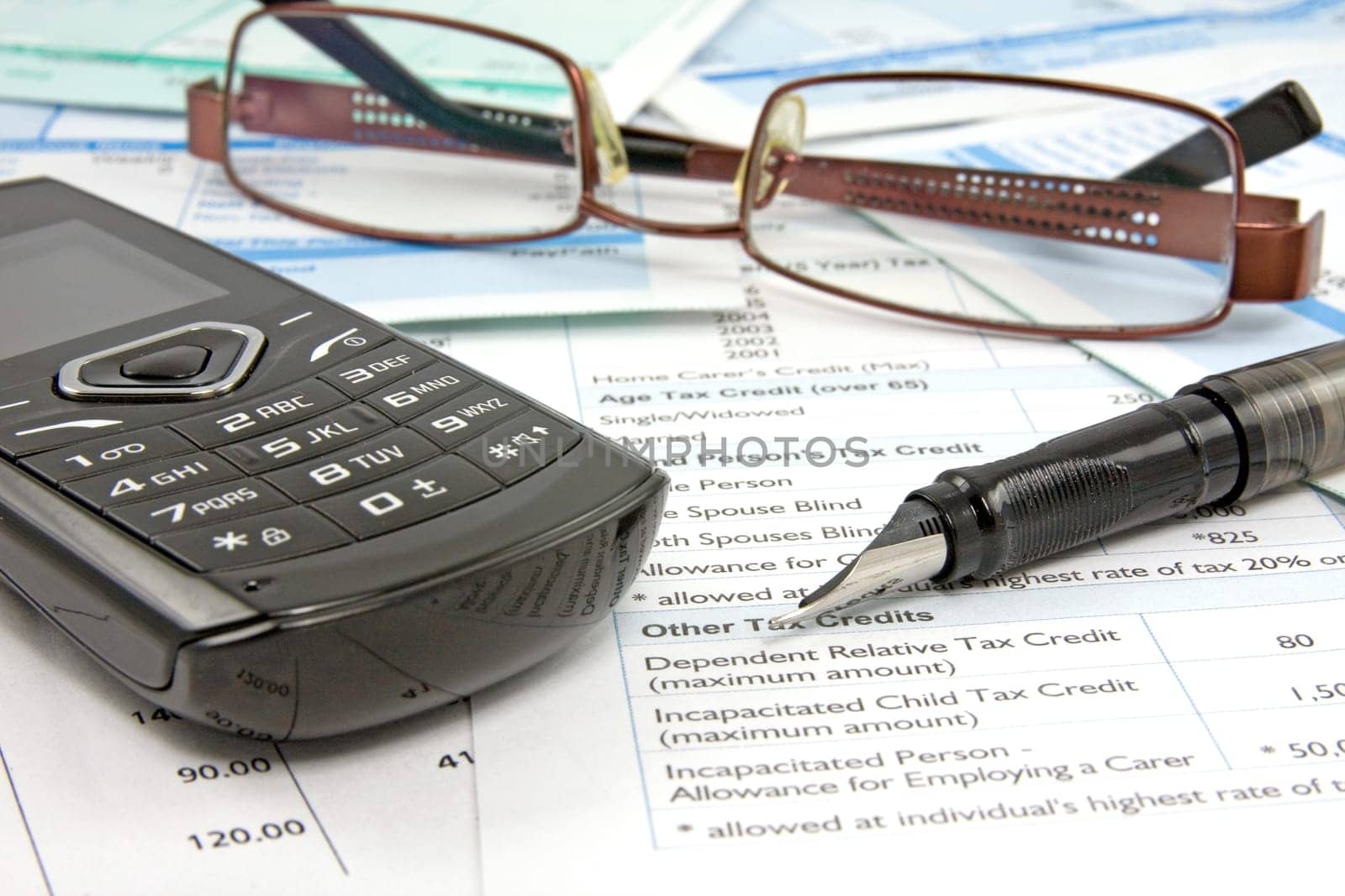 Financial reports with pen,mobile phone and glasses