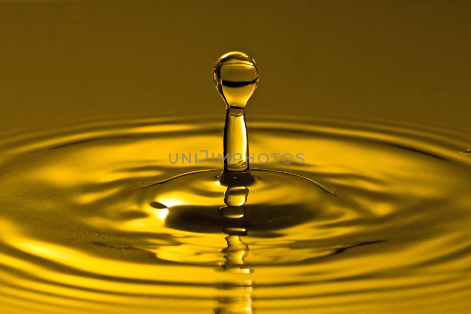 close-up of droplet splash in a golden water