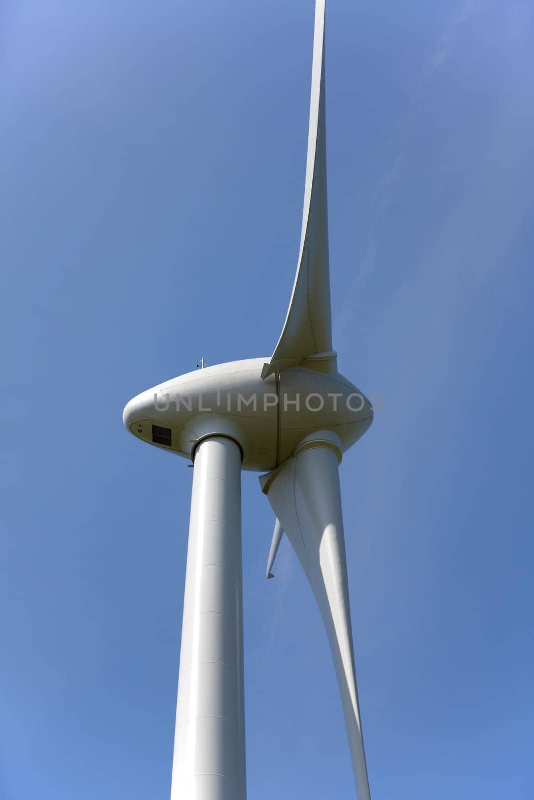 Close-up of a wind turbine in front of a blue sky