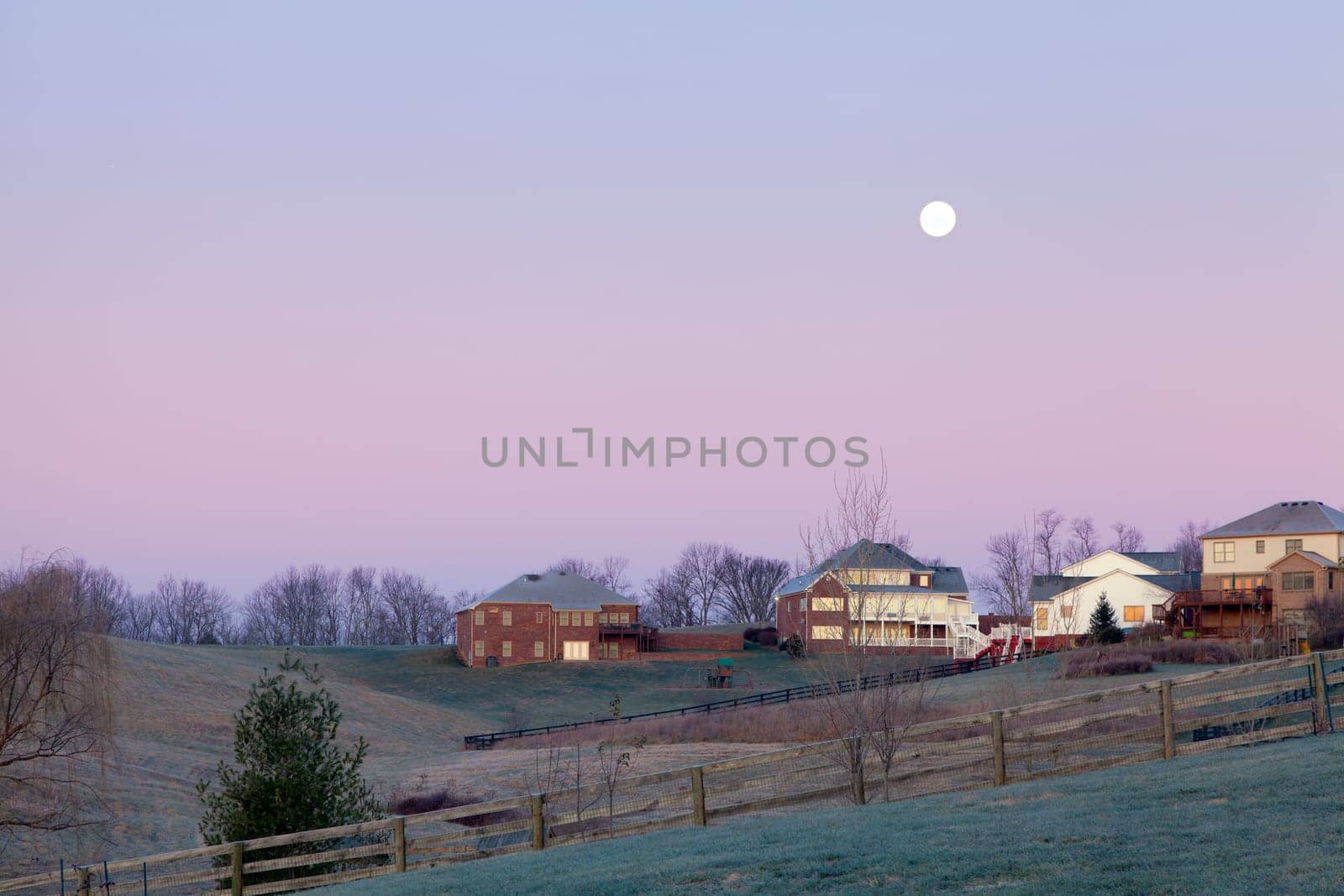 Moon setting over a suburban residential neighborhood