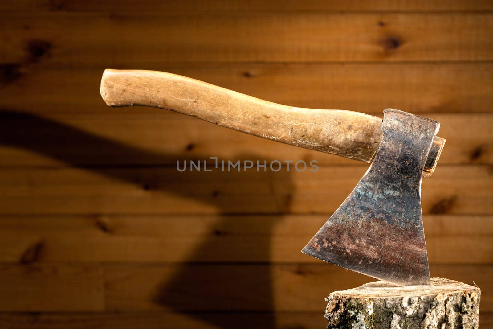 Image of an old axe against a wood panel background
