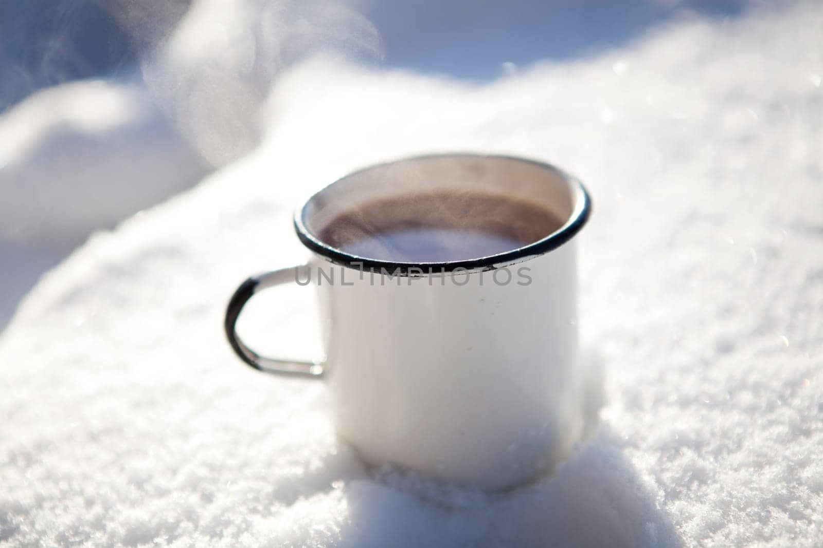 Mug of hot chocolate outdoors on a winter day in snow