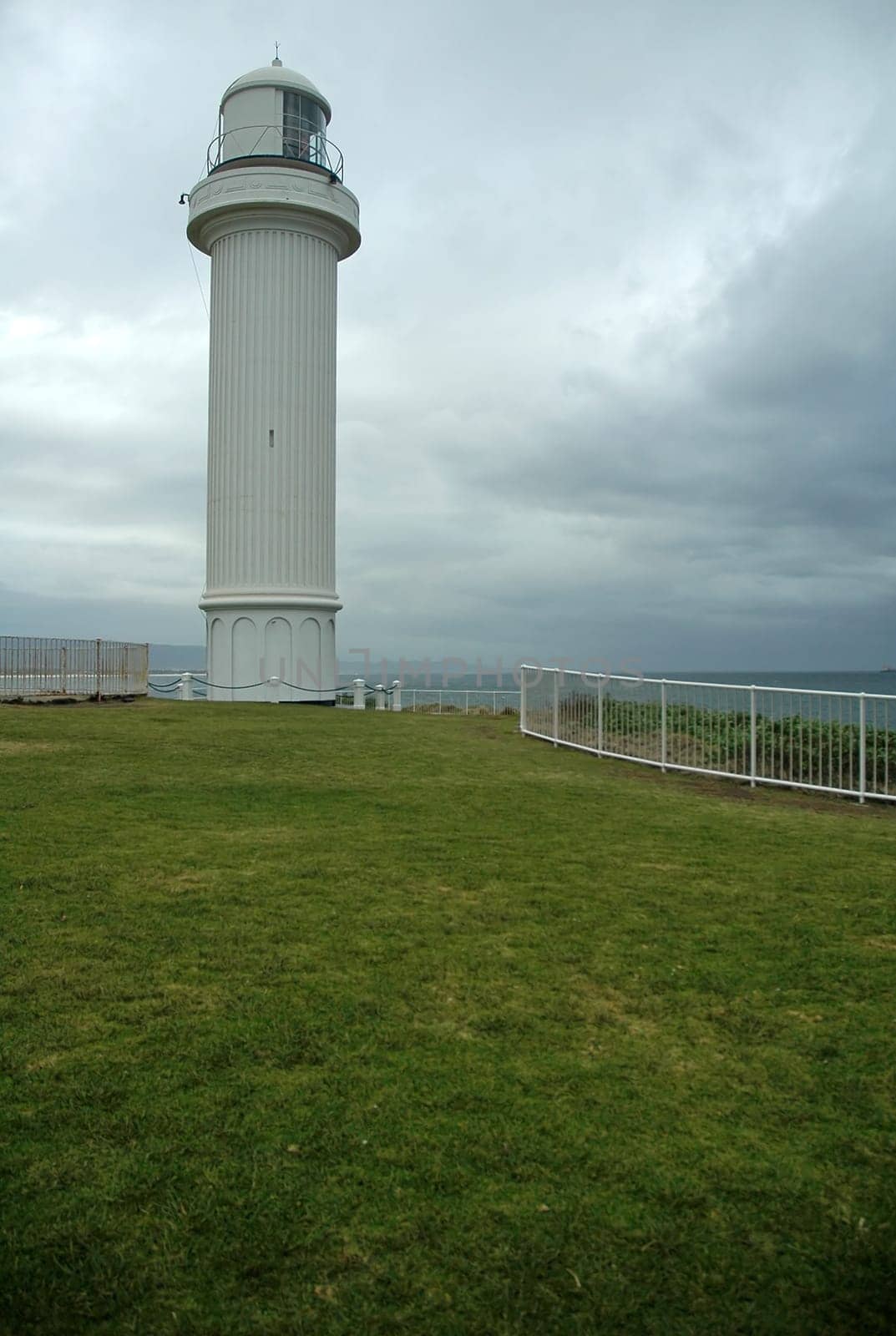 white lighthouse, dark grey sky, almost raining, coastline near sydney