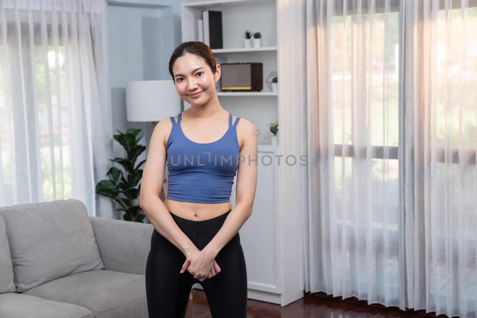 Asian woman in sportswear portrait, smiling and posing cheerful gesture. Home workout training or exercise fitness lifestyle. Attractive girl engage in her pursuit of healthy lifestyle. Vigorous