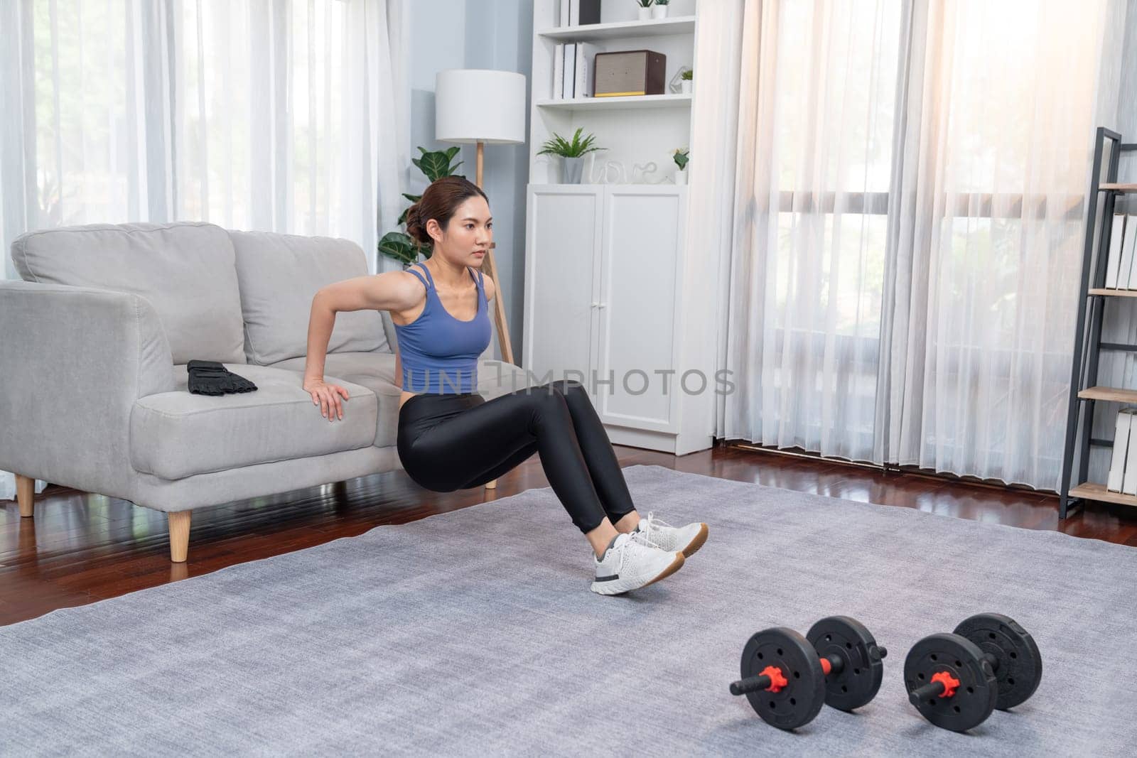 Energetic and determination asian woman push up on sofa. Vigorous by biancoblue