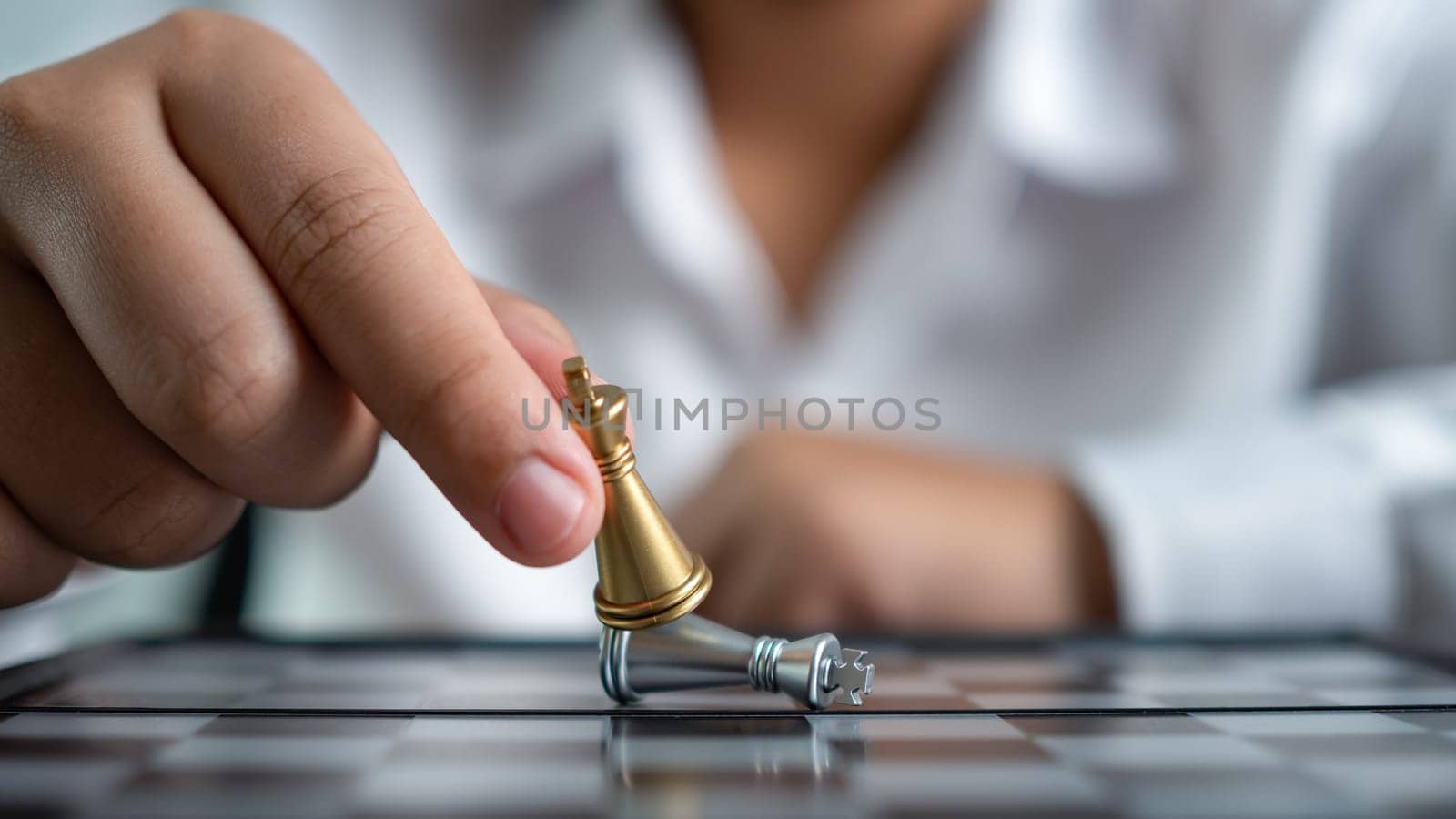 Businessman holding a king fighting on a chessboard represents concept of competition and strategy adjustment for competitors in business. by Unimages2527