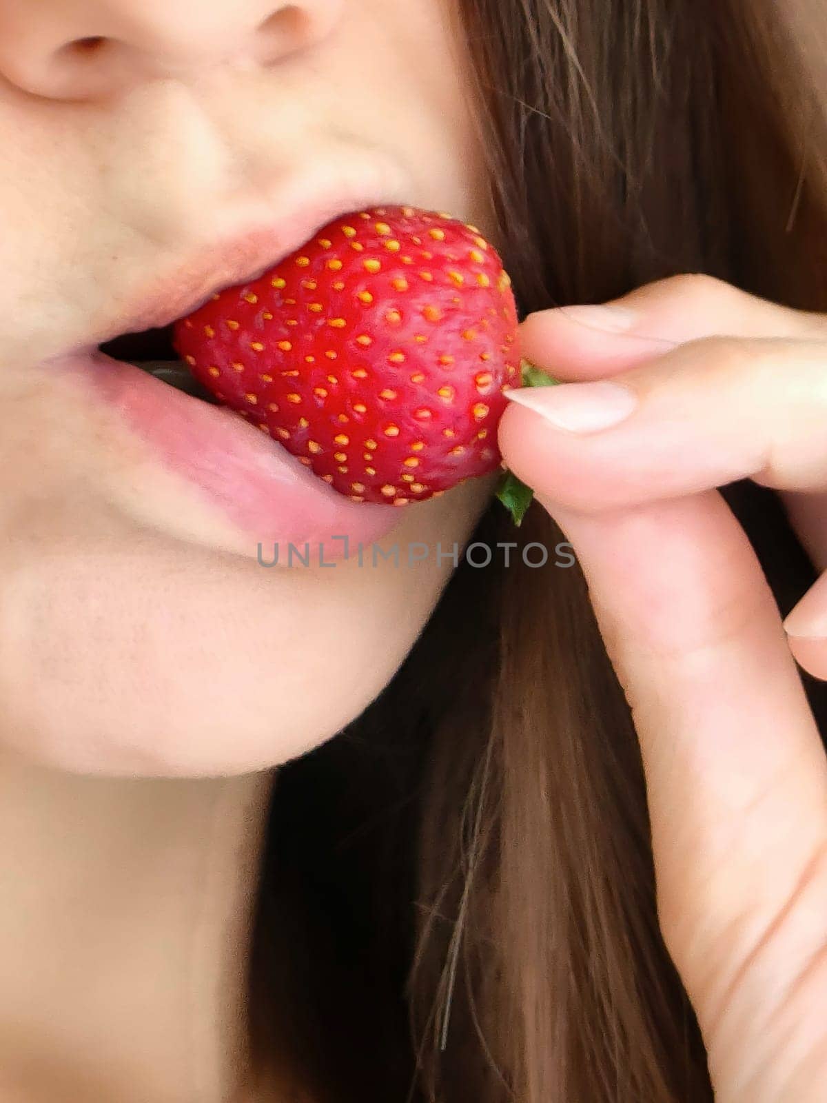 Girl bites strawberry, sensual lips and strawberry close-up