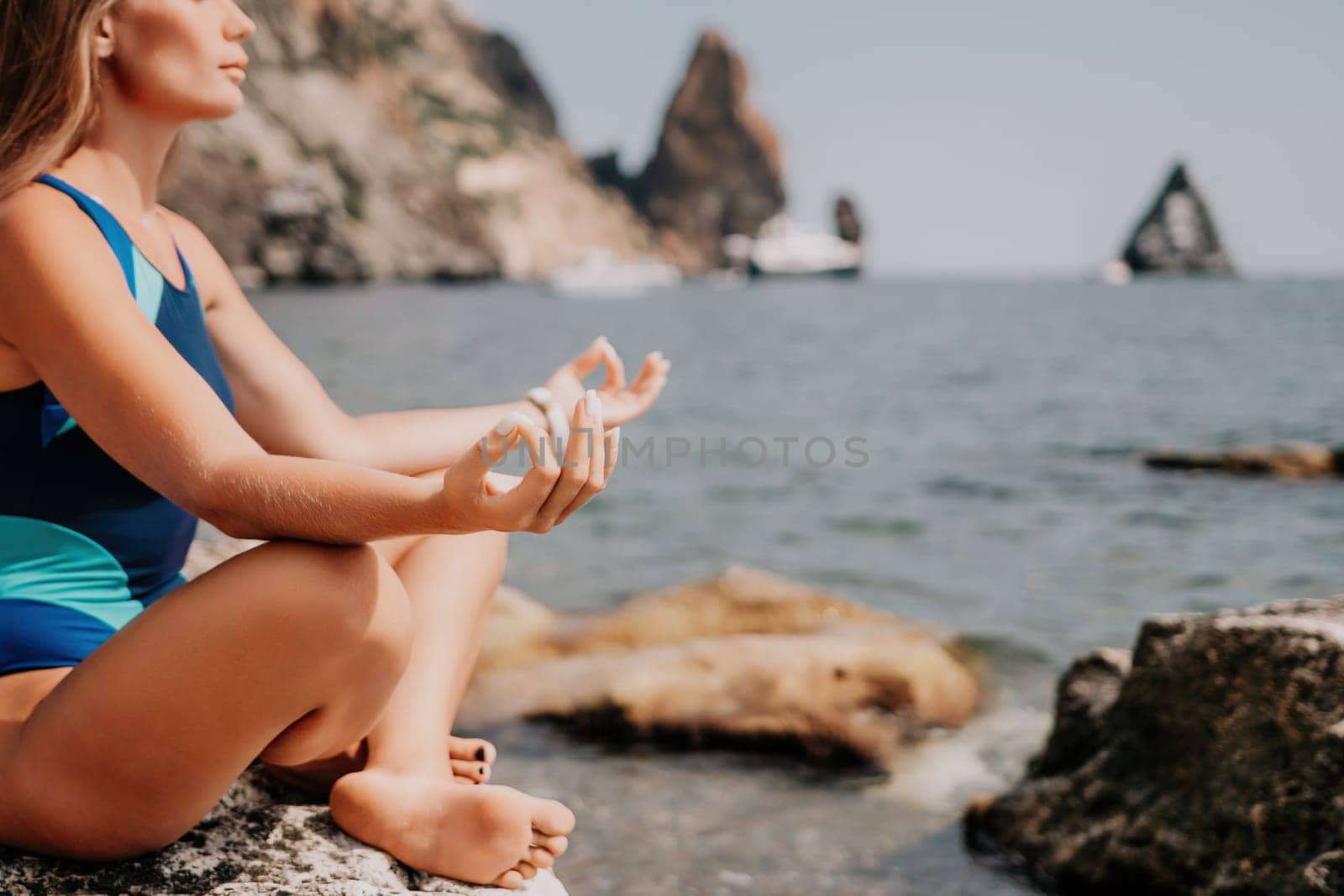 Woman sea yoga. Happy woman meditating in yoga pose on the beach, ocean and rock mountains. Motivation and inspirational fit and exercising. Healthy lifestyle outdoors in nature, fitness concept. by panophotograph