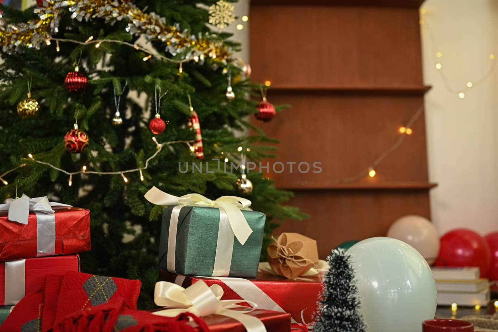 Beautiful decorated Christmas Tree with gift boxes on floor in living room. Winter holiday celebration concept.