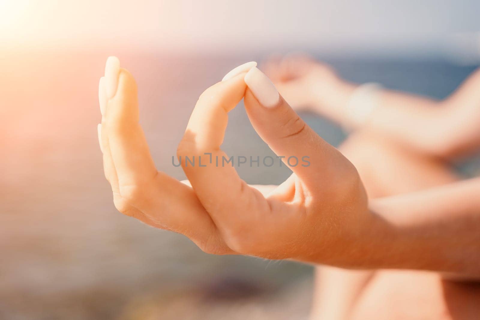 Woman sea yoga. Happy woman meditating in yoga pose on the beach, ocean and rock mountains. Motivation and inspirational fit and exercising. Healthy lifestyle outdoors in nature, fitness concept. by panophotograph