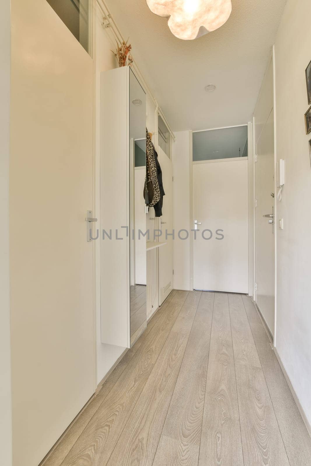 a hallway with white doors and a wardrobe and a by casamedia