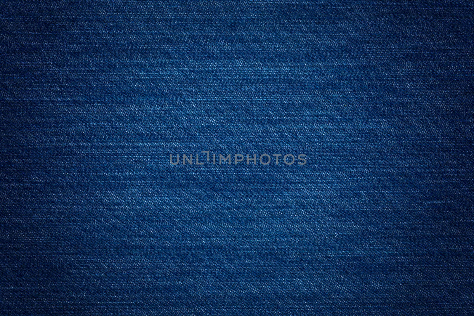 Dark blue denim background, detailed texture with vignette