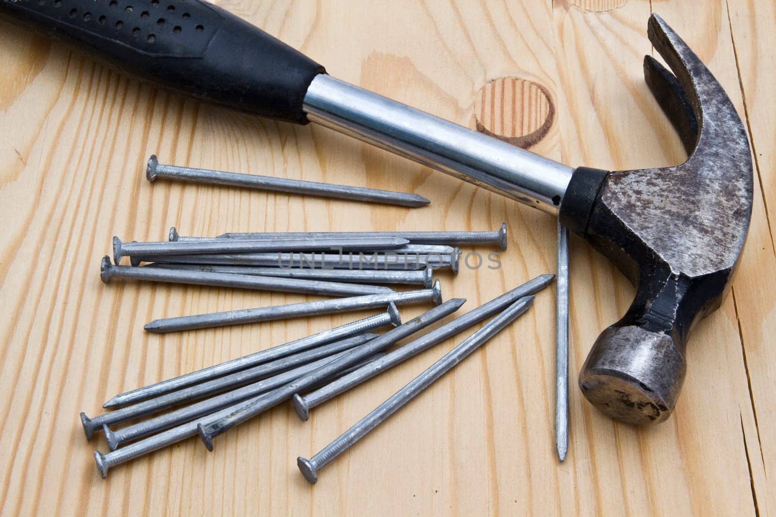 Old hammer and nails on wood background