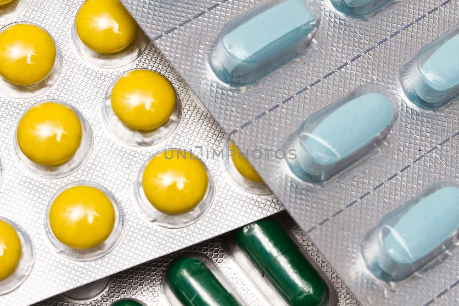 Colorful pills and capsules closeup on white background