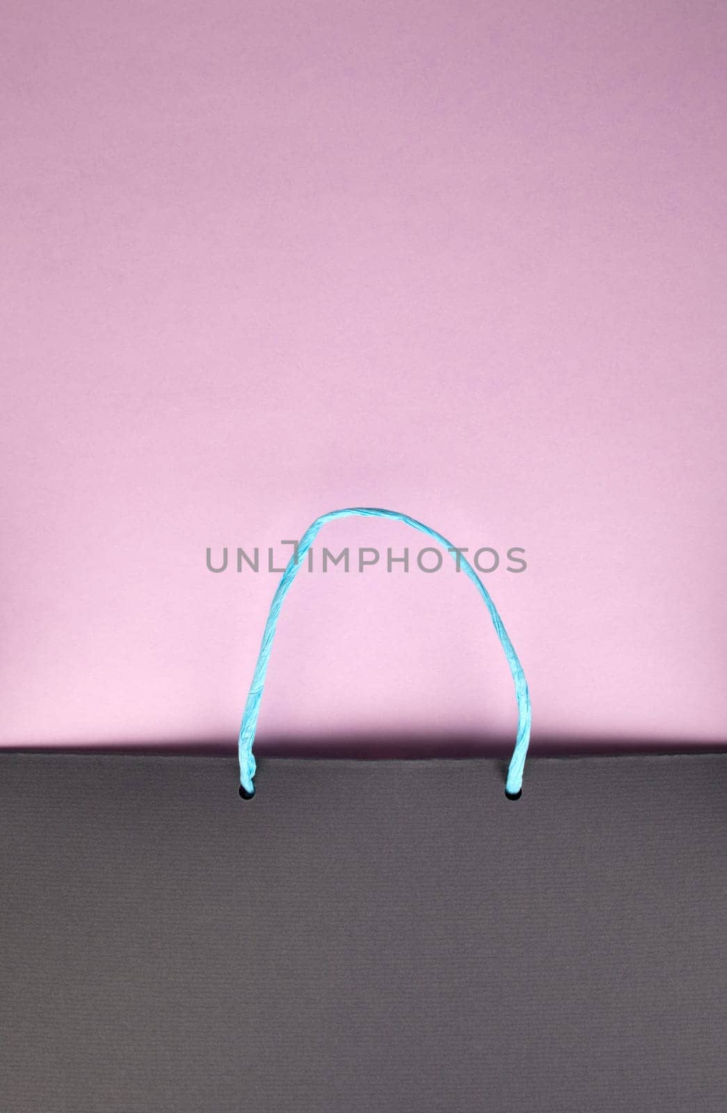 Paper bag with handles on pink cardboard