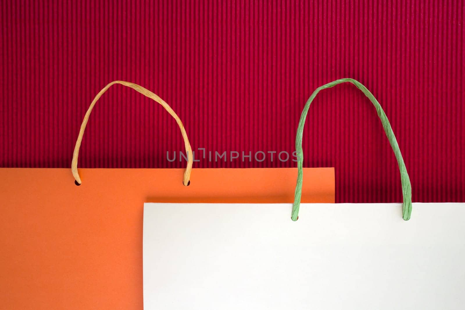 Paper bag with handles on red background