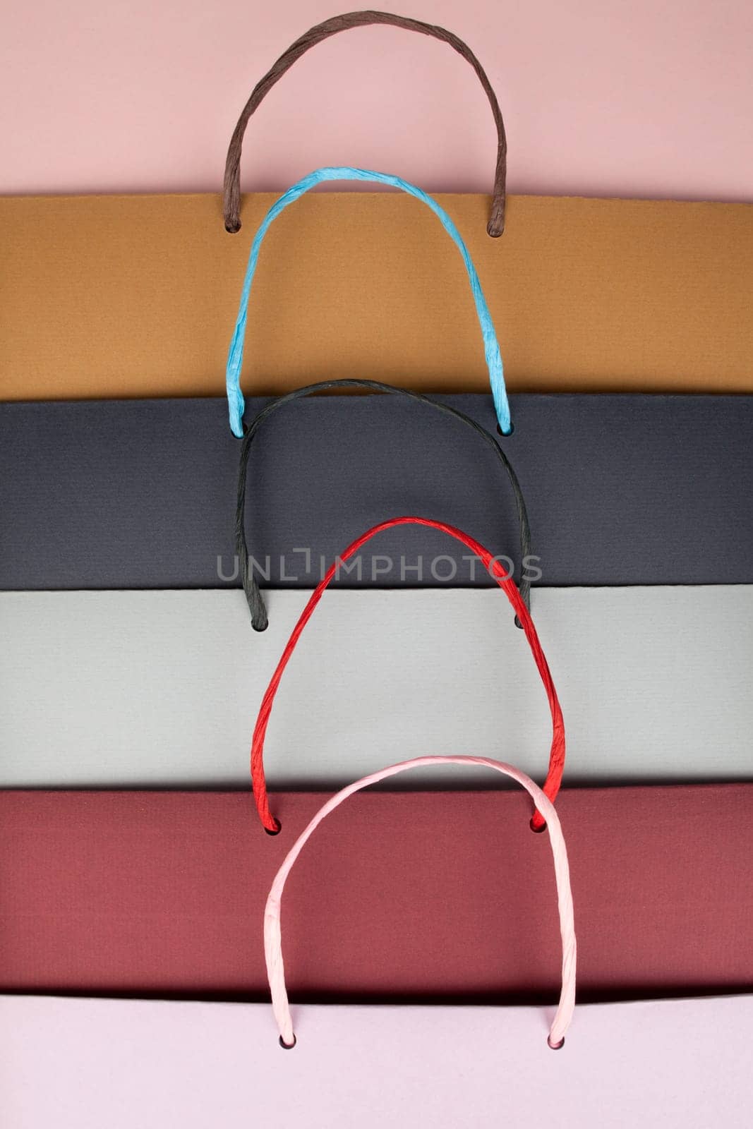 Paper bags with handles on pink cardboard
