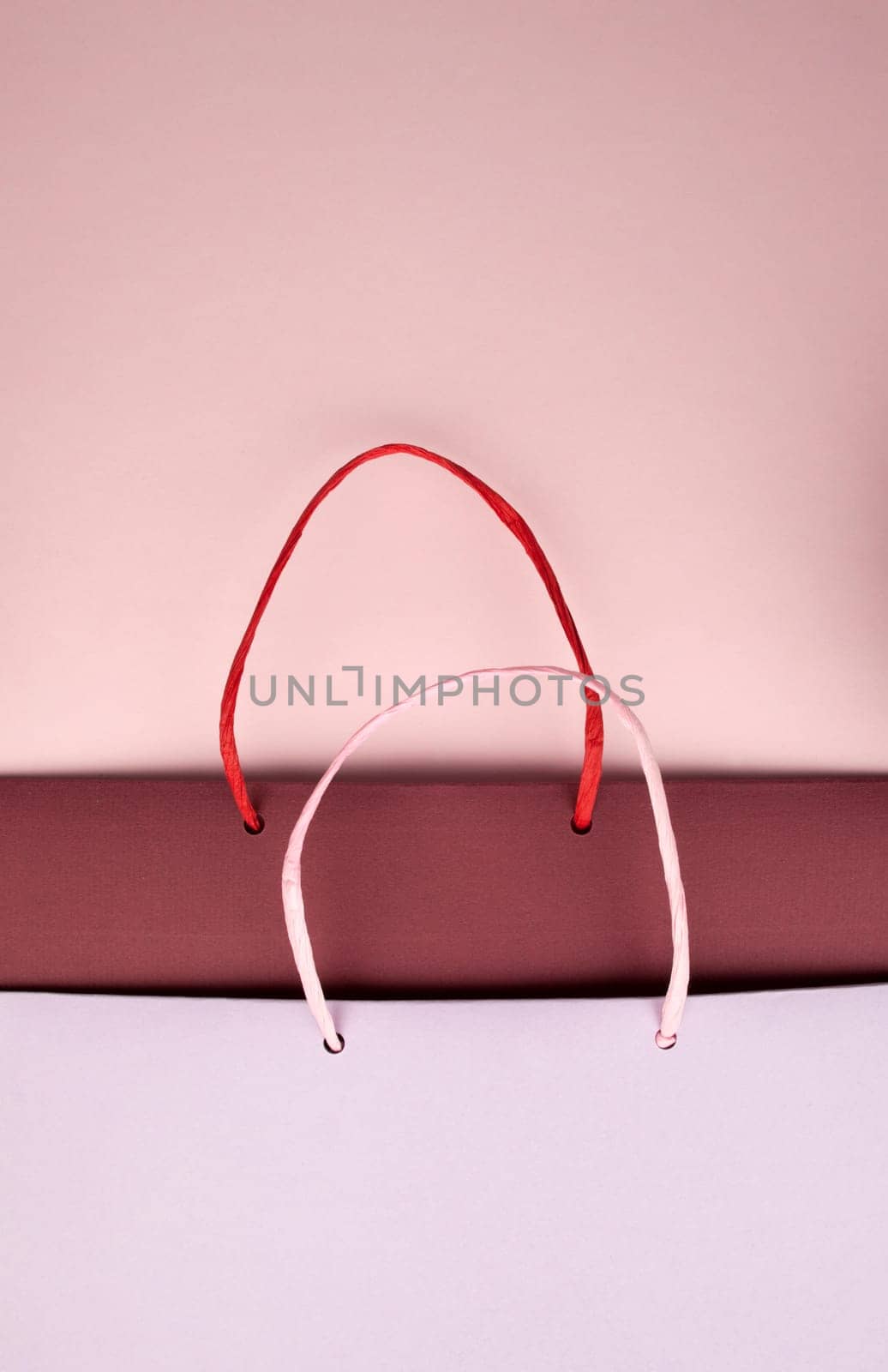 Paper bag with handles on pink cardboard