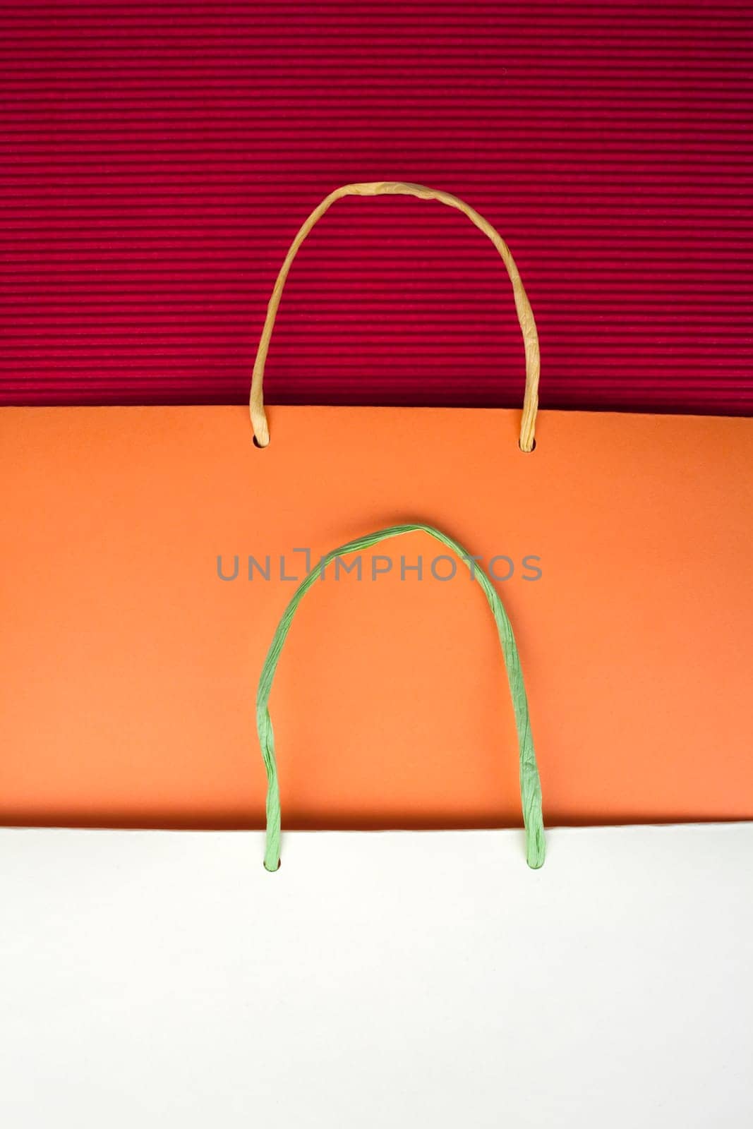 Paper bag with handles on red background