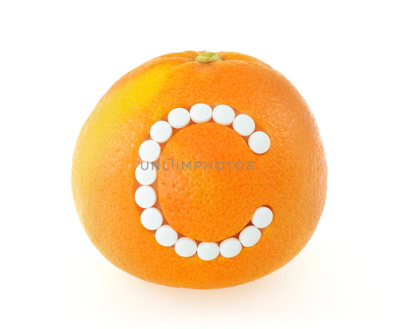 Grapefruit with vitamin c pills over white background - concept