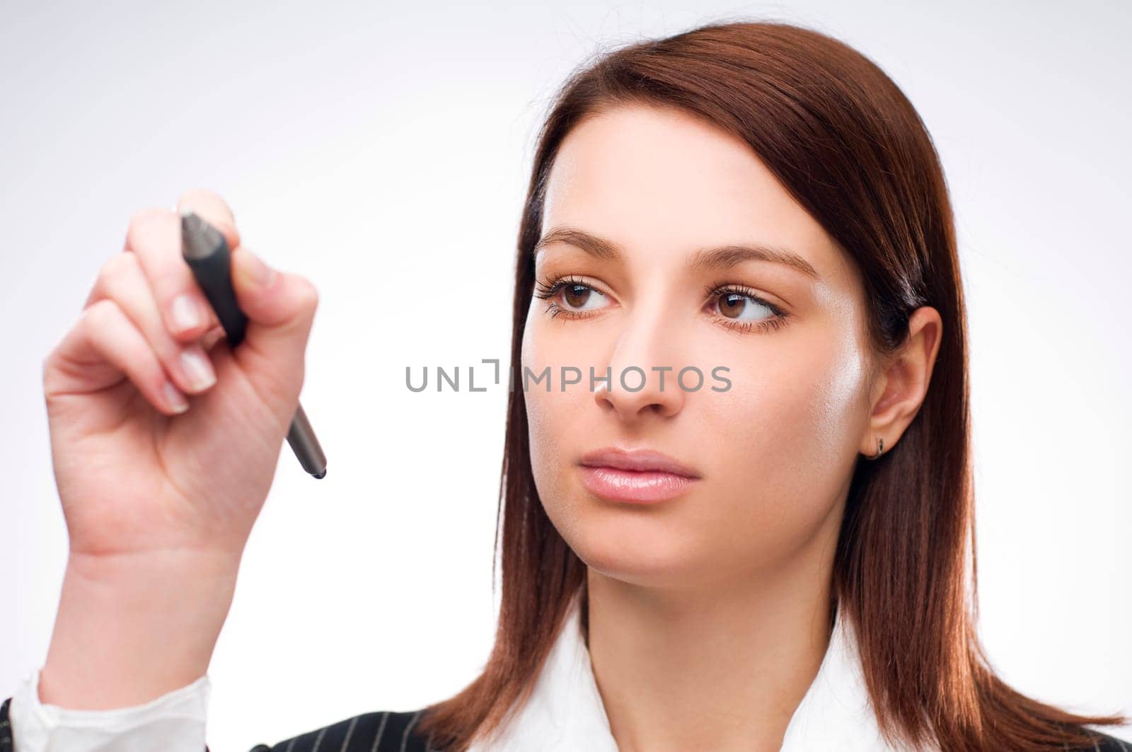 Young business woman writing on glass close up