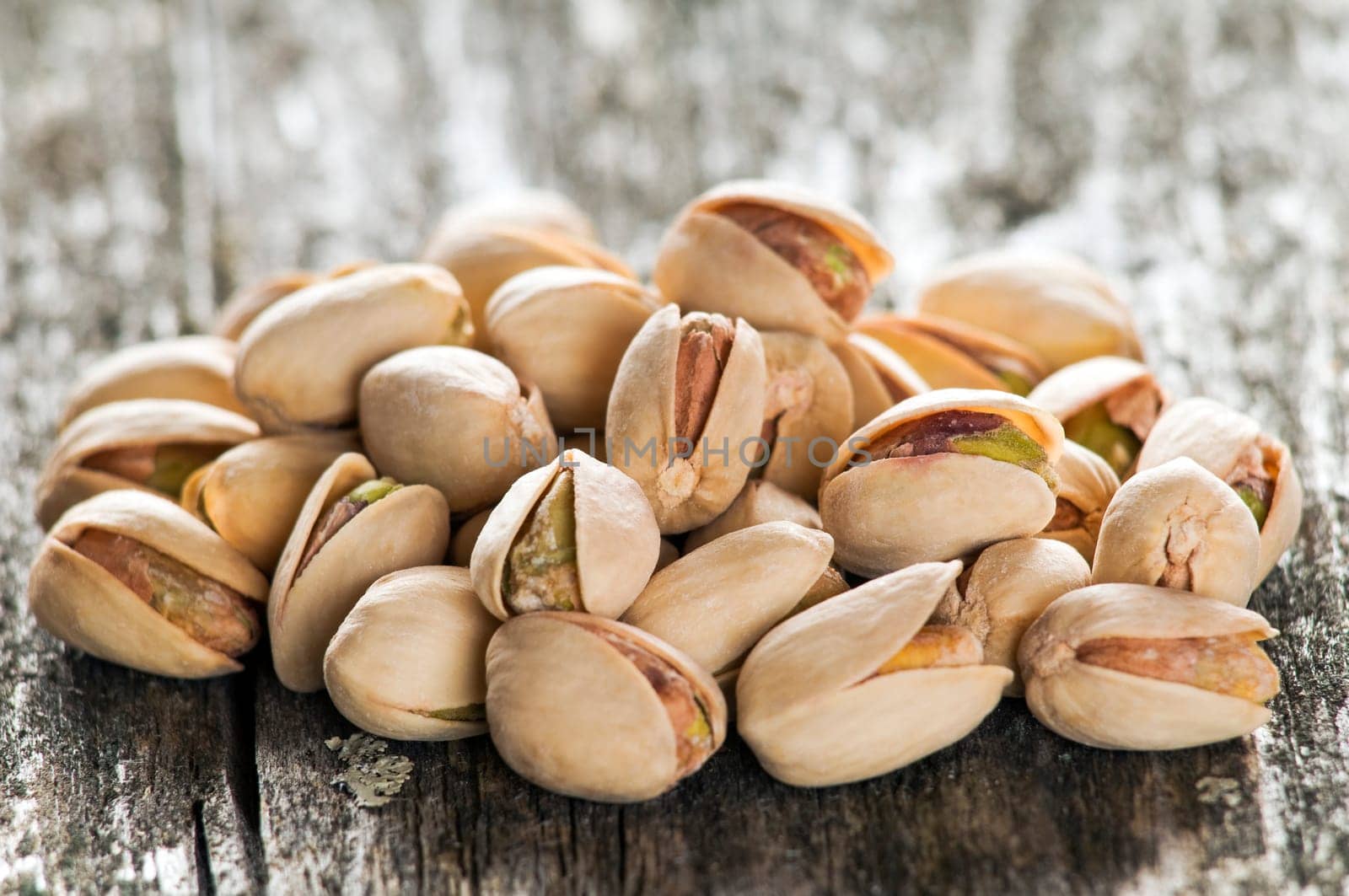 beautiful pistachio seeds on wood close up