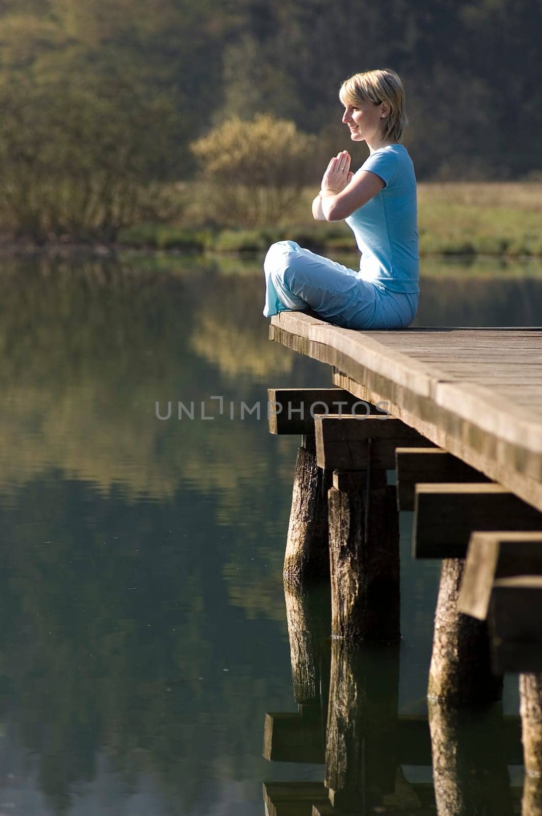 young girl relaxing on pier in early morning