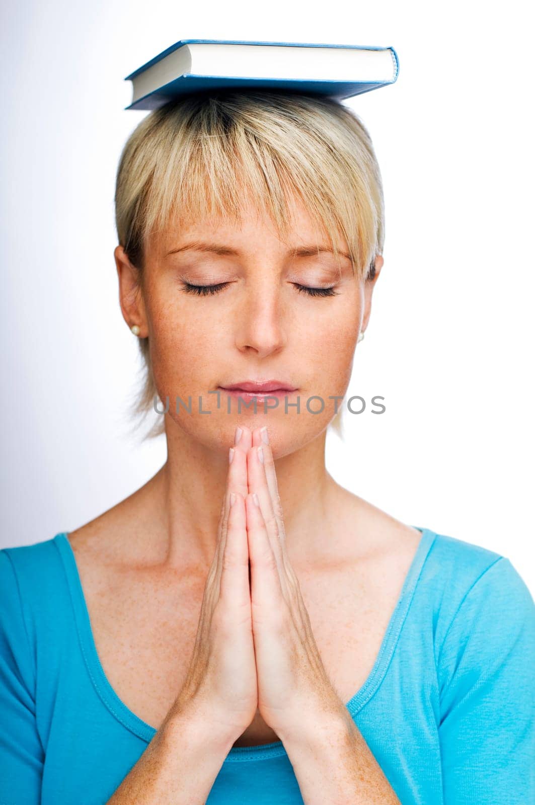 young woman relaxing with book on her head