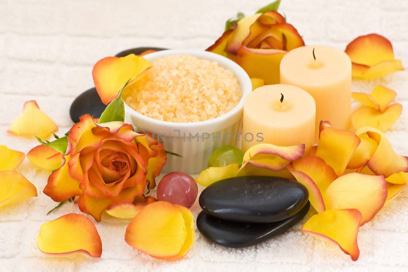 bowl of bath salt with rose petal and massage stones and candles - body care