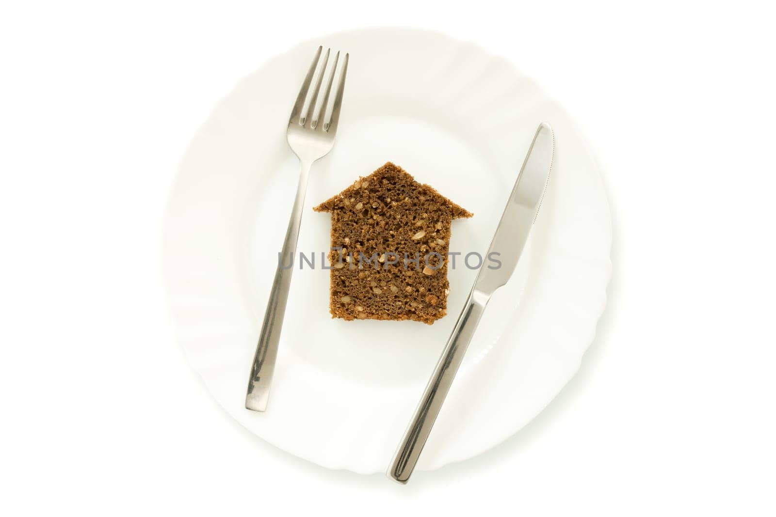 The silhouette of the house from bread lays on a plate