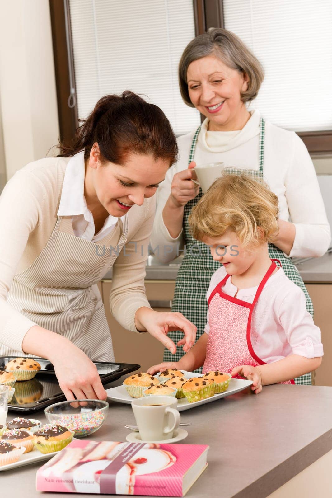 Grandmother, mother and child girl making cupcakes in kitchen