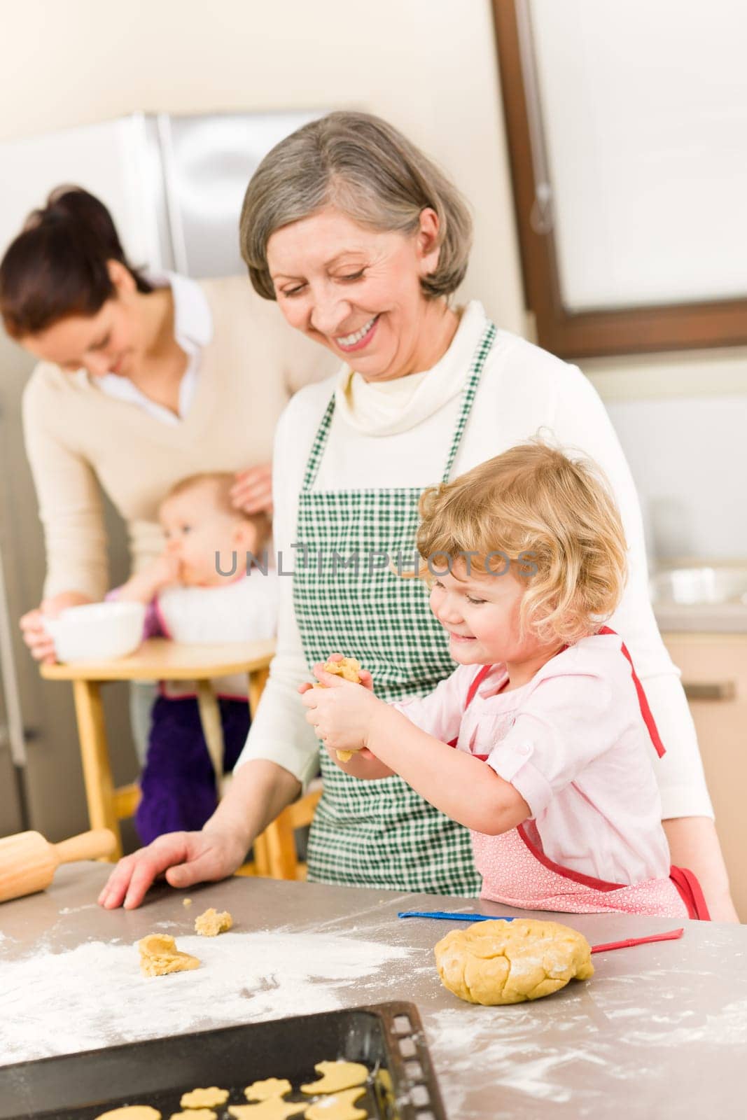 Grandmother with little girl prepare dough for baking in kitchen