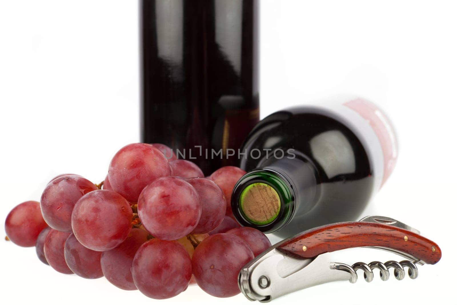 Wine bottle with corkscrew and grapes