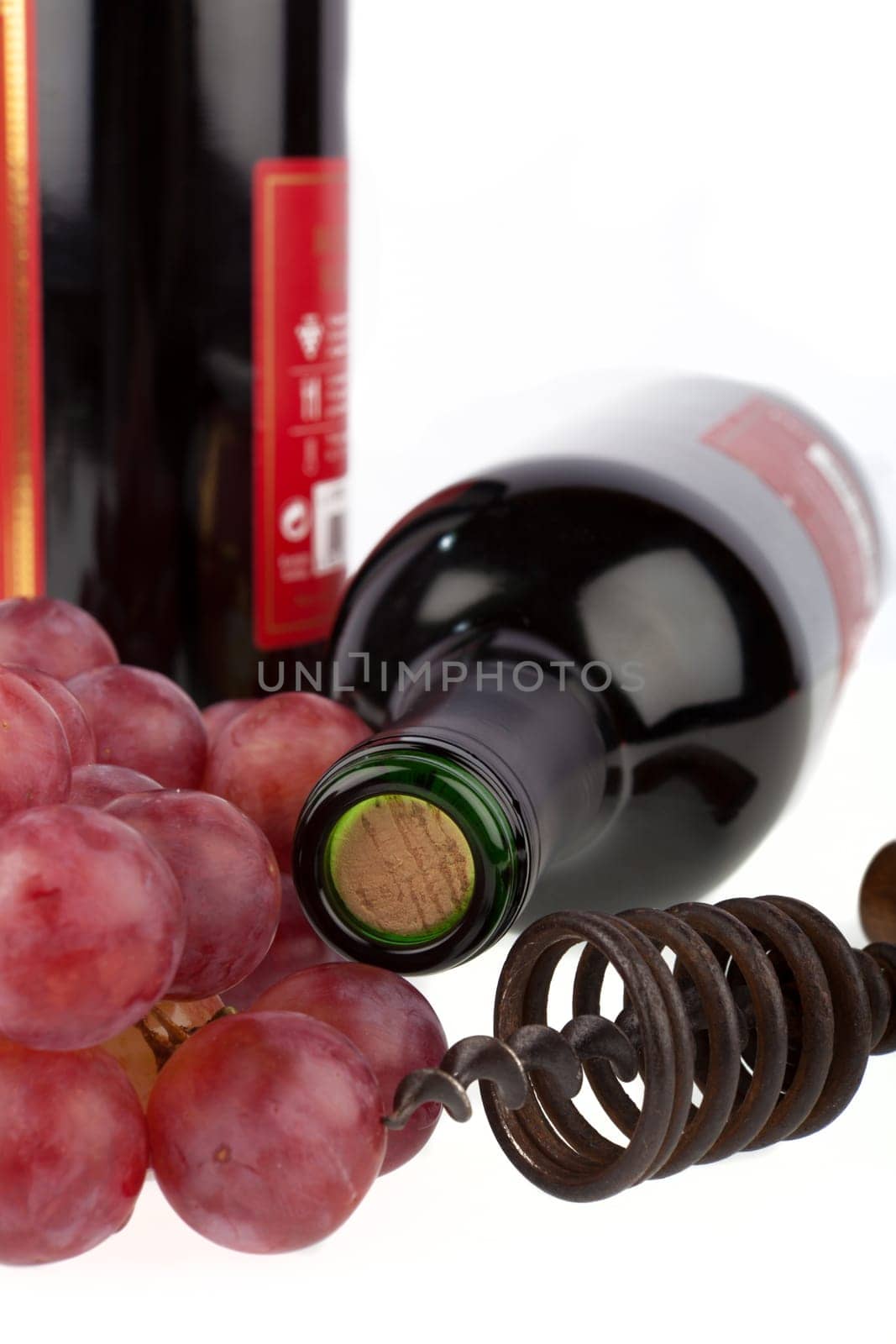 Wine bottle with corkscrew and grapes