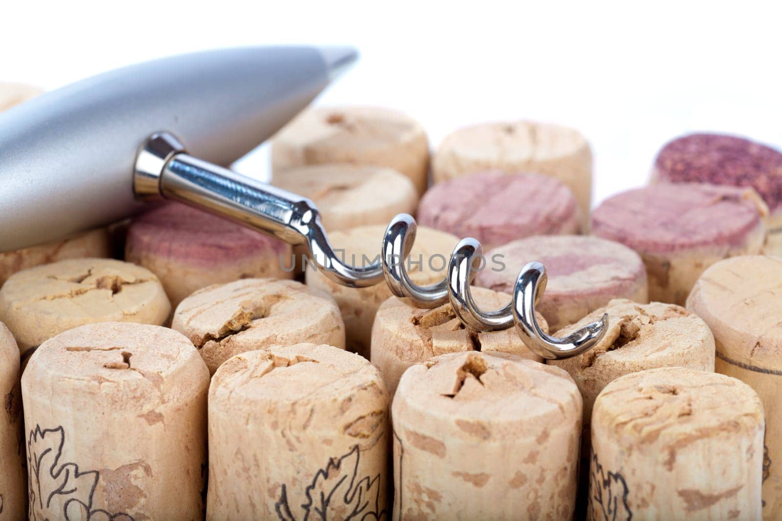 Close-up of a corkscrew lying on a stack of corks