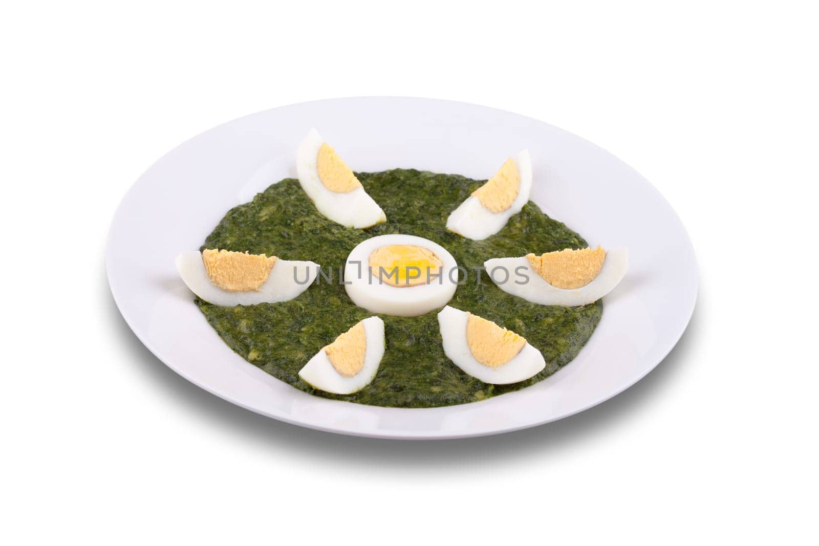 Creamy spinach with a boiled egg in a plate. Isolated white background.